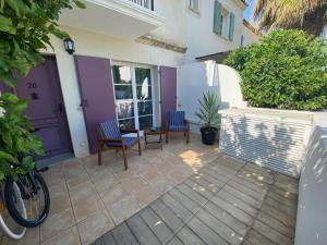 a patio with two chairs and a purple door at Marina 26 in Aigues-Mortes
