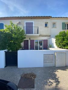 a white building with a fence in front of it at Marina 26 in Aigues-Mortes
