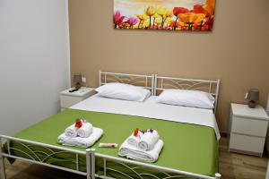 um quarto com uma cama com toalhas em Alex Home em Taranto