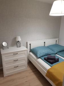 a bedroom with a bed and a dresser with a lamp at Apartament Monika in Kłodzko