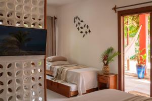 a bedroom with two beds and a mirror at Swiss Garten Jeri in Jericoacoara