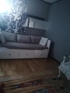a living room with a couch in the corner at Charmant Appartement 10mn Rouen in Franqueville-Saint-Pierre