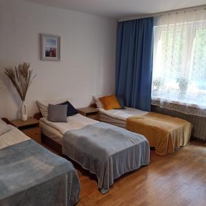 een kamer met 3 bedden en een raam bij Kwatera u Kasi in Świnoujście