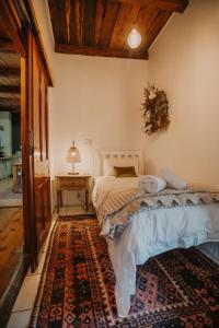a bedroom with a bed and a table on a rug at Sionsberg Farmstay in Riversdale