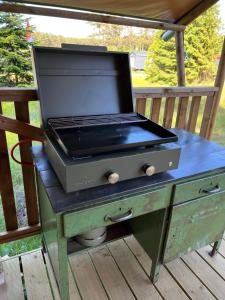 einem Grill, der auf einem Tisch auf einem Deck sitzt in der Unterkunft Glampingzelt Heide - Lodge in Soltau