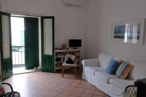 a living room with a white couch and a television at Sapore di sale in Cava dʼAliga