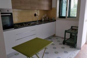 a kitchen with a green table and a sink at Sapore di sale in Cava dʼAliga