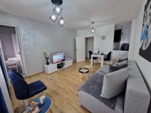 ein Wohnzimmer mit einem Sofa und einem Esszimmer in der Unterkunft Apartman Astra in Sremska Mitrovica