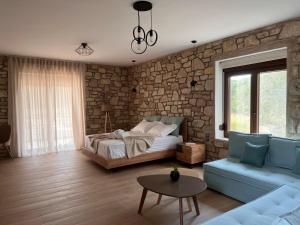 a bedroom with a bed and a stone wall at Michelangelo suites and apartments in Valanidorachi