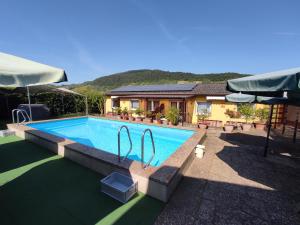 a swimming pool in front of a house at Moselferienweingut Schaefer in Wintrich