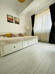una camera bianca con un grande letto e una finestra di Orhideea Central Apartments a Bucarest