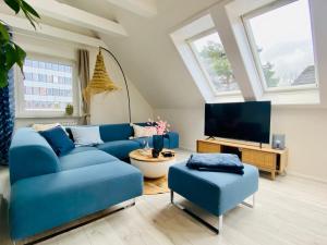 a living room with a blue couch and a tv at Ostseewelle, Parkplatz in Kiel