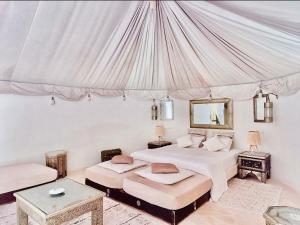 1 dormitorio con 2 camas y dosel en Les jardins d isis en Marrakech