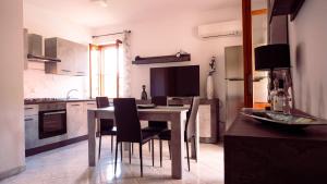 cocina con mesa y sillas en una habitación en PM Villa Arenosu Guest House en Fertilia