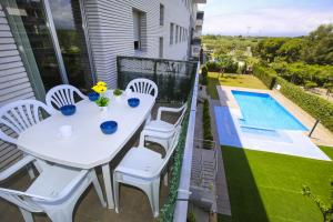 a white table and chairs on a balcony with a pool at JOEL 2 Planetcostadorada ONLY FAMILIES in Salou