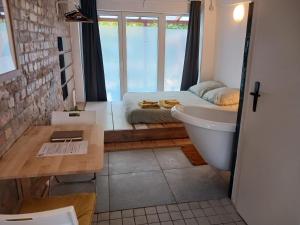 Squat Deluxe Berlin, the hostel في برلين: حمام به سرير وحوض استحمام ومغسلة