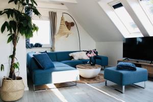 a living room with a blue couch and a tv at Ostseewelle, Parkplatz in Kiel