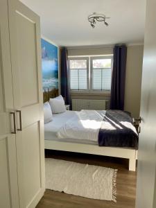 sypialnia z łóżkiem i oknem w obiekcie Sonnendeck 3 w Zingst