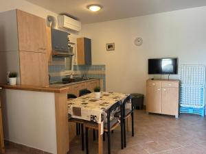 a kitchen with a table with chairs and a dining room at Apartmani Roko in Baška