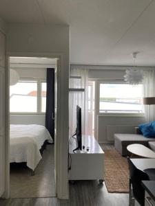 ein Schlafzimmer mit einem Bett und ein Wohnzimmer mit einem Sofa in der Unterkunft Viihtyisä huoneisto keskustassa. in Kotka