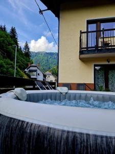 a bath tub with a waterfall in front of a house at House Utrinek with free play room, jacuzzy and garage in Podbrdo