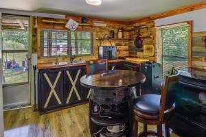 una cucina con bar e tavolo in una cabina di Cozy Cabin Near Lake Hartwell and Clemson University ad Anderson