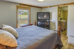 1 dormitorio con 1 cama y TV de pantalla plana en Cozy Cabin Near Lake Hartwell and Clemson University, en Anderson
