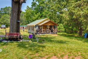 una cabina nell'erba vicino a un albero di Cozy Cabin Near Lake Hartwell and Clemson University ad Anderson