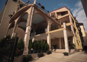 un bâtiment doté d'une arche avec des plantes en pot dans l'établissement Hotel Irise, à Kobuleti