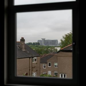 a view from a window of houses and a large building at 4 Bedrooms Homely House - Sleeps 6 Comfortably with 6 Double Beds,Glasgow, Free Street Parking, Business Travellers, Contractors, & Holiday-Goers, Near All Major Transport Links in Glasgow & City Centre in Glasgow