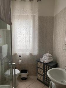 a bathroom with a sink and a toilet and a window at La Rosa del Garda in Peschiera del Garda