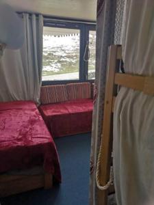 een kamer met twee stapelbedden en een raam bij J'Aime la montagne in Mâcot La Plagne