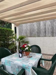 a table with a bottle of wine and flowers on it at La Rosa del Garda in Peschiera del Garda
