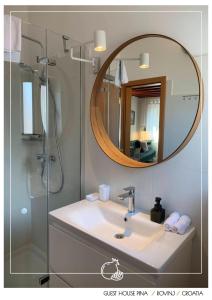a bathroom with a sink and a shower with a mirror at Guest House Pina in Rovinj +30 photos