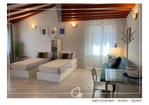 a bedroom with two beds and a couch and a table at Guest House Pina in Rovinj
