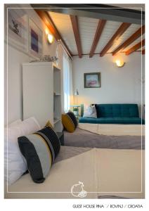 1 dormitorio con 2 camas y sofá azul en Guest House Pina, en Rovinj