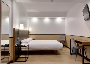 - une chambre avec un lit, un bureau et une table dans l'établissement Hotel Costa Atlántica, à Arteixo