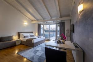 a room with a bed and a couch and a table at Hi room vicolo del vò in Trento