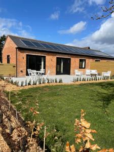 a house with solar panels on the roof at Appletree - a newly converted luxury barn in Warwickshire on our farm in Evesham
