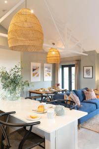 a living room with a blue couch and a table at Appletree - a newly converted luxury barn in Warwickshire on our farm in Evesham