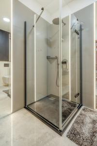 a shower with glass doors in a bathroom at Łódź Retreat Apartments - Terrace, Garden & Parking - by Rentujemy in Łódź