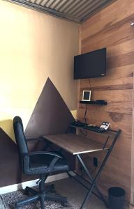 a desk with a chair and a monitor on a wall at Area 3251 Desert Valley Guest Suite in Pahrump