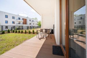 a balcony with a table and chairs on it at Łódź Retreat Apartments - Terrace, Garden & Parking - by Rentujemy in Łódź
