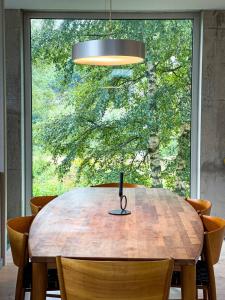 una mesa de madera con sillas y una ventana grande en Havgaarden Villa, en Stapnes