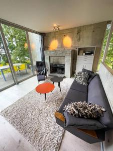 sala de estar con sofá y chimenea en Havgaarden Villa, en Stapnes