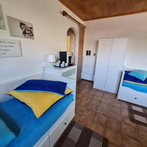 Schlafzimmer mit einem Bett mit blauen und gelben Kissen in der Unterkunft Ferienwohnung W.Esel in Wesel