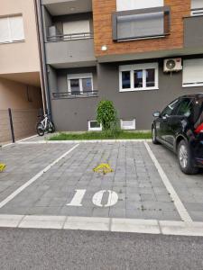 a car parked in a parking lot in front of a building at Apartman Astra in Sremska Mitrovica