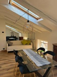 een woonkamer met een glazen tafel en stoelen bij La mansardina in Trieste