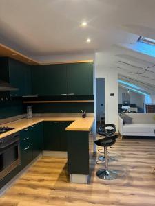 een keuken met groene kasten en een tafel en een bank bij La mansardina in Trieste