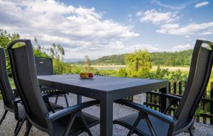 a black table and chairs on a patio with a view at B&B Gösselsdorfer Seeblick in Sittersdorf